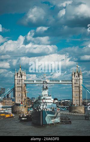 The HMS Belfast town-class light cruiser with the Tower Bridge in the background in London, UK Stock Photo