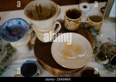 The beautiful hand-made ceramic plates and cups displayed on the table Stock Photo
