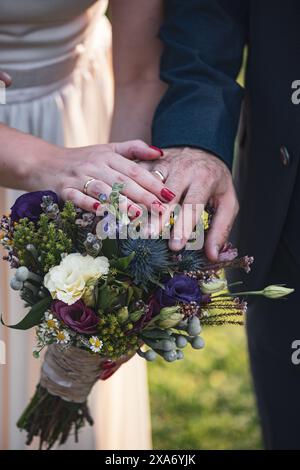 The wedding rings placed on a bridal bouquet. Stock Photo