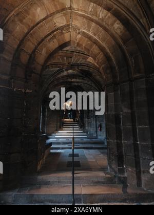 A narrow walkway with arched walls leading to buildings Stock Photo