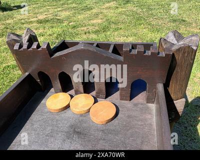 A wooden object with three pieces of wood placed on green grass lawn Stock Photo