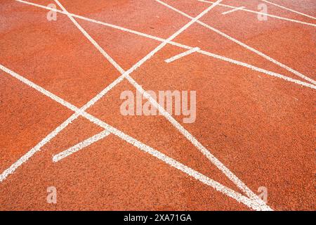 The bright red runway interweaves the straight white trajectory with the curved white trajectory. Stock Photo
