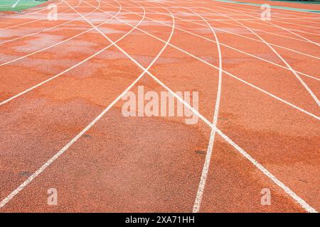 The bright red runway interweaves the straight white trajectory with the curved white trajectory. Stock Photo
