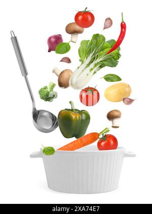 Fresh ingredients falling into saucepan on white background Stock Photo