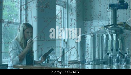 Image of scientific formulas over female scientist using tablet and smelling liquids in laboratory Stock Photo