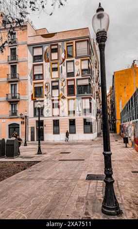 An old street lamp stands in front of colorful city buildings Stock Photo