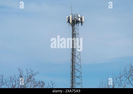 A telecommunications tower standing tall against a clear blue sky. Stock Photo