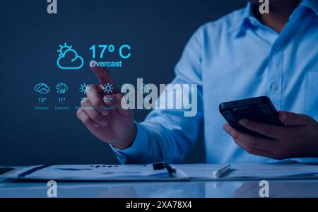 Hands holding smartphone with Weather forecast widget concept. cloudy, rainy and sunny day concept, touchscreen device with different seasons and dail Stock Photo