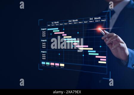 Project manager working on virtual screen and updating tasks and milestones progress planning with Gantt chart scheduling interface for company on vir Stock Photo