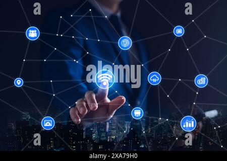 Smart business IOT, internet of things concept. Businessman touching IOT icon on virtual screen, connected internet network to access AI intelligence, Stock Photo