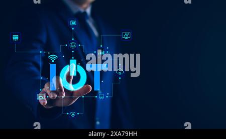 Smart business IOT, internet of things concept. Businessman touching IOT icon on virtual screen, connected internet network to access AI intelligence, Stock Photo