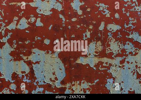 Chipped red paint on metal surface with peeling paint texture Stock Photo