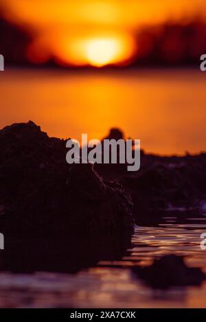 Close-up of water with rocks in the background during sunset Stock Photo