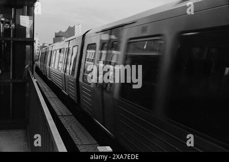 A monochrome image of a train arriving at a station Stock Photo