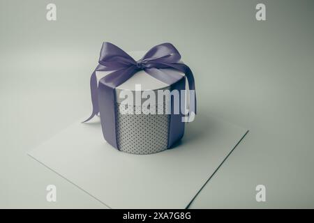 A round gift box with purple ribbon on top Stock Photo