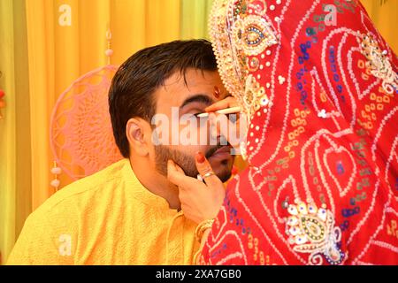 A woman applying eyeliner to a man Stock Photo