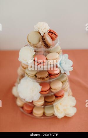 A tower of macarons and flowers on a table Stock Photo