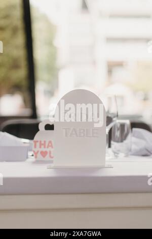 An elegant wedding table setting with white napkins, glassware, and wine glasses Stock Photo
