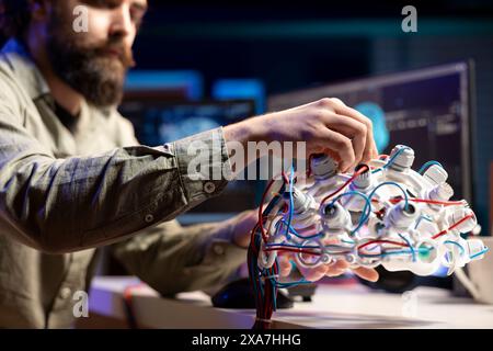 Computer scientist installing electrodes wires on EEG headset to communicate with artificial intelligence entity. Close up shot of high tech gear used by IT expert to talk with AI robot Stock Photo
