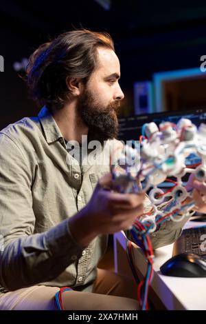 Computer scientist using EEG headset to upload his mind into computer, attaining immortality. Software developer in apartment experimenting with transferring consciousness into cyberspace Stock Photo