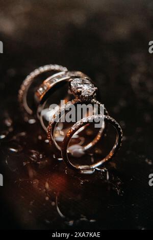 Close-up of two gold wedding bands on dark marble background Stock Photo