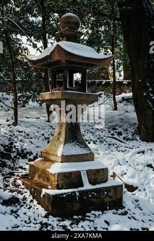 The Ancient style traditional Japanese lantern covered in rare winter snow at Fushimi Inari Shrine in Kyoto Japan. Stock Photo