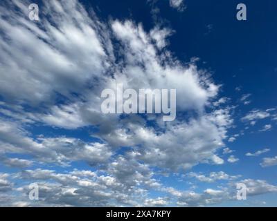 Bright blue sky with an assortment of fluffy clouds on a sunny day Stock Photo