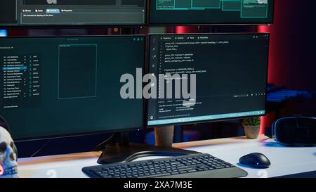 Close up shot of dangerous hacking code running on high tech computer system monitors. Programming scripts shown on PC displays in empty criminal hideout used by hackers to commit illegal activities Stock Photo