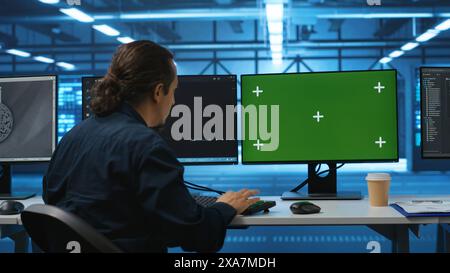 Engineer in server hub using green screen PC to repair equipment storing datasets. Professional using mockup computer to do debugging on rigs doing computational operations Stock Photo