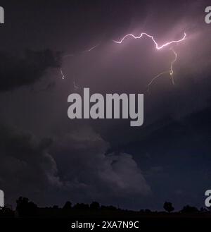 Lightning strikes across the night sky Stock Photo