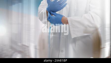 Image of midsection male doctor putting surgical gloves on Stock Photo