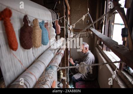 June 5, 2024, Srinagar, Jammu And Kashmir, India: A Kashmiri artisan weaves a traditional carpet at a factory in the old city of Srinagar. The history of Kashmiri carpets dates back to Hazrat Mir Syed Ali Hamdani, a Sufi mystic from Persia who introduced skilled artisans and carpet weaving to Kashmir via the Silk Route. The craft peaked during Zain-al-Abidin's reign, gaining global recognition. Traditionally, this art is passed down from father to son, preserving its intricate techniques and luxurious designs. (Credit Image: © Adil Abass/ZUMA Press Wire) EDITORIAL USAGE ONLY! Not for Commercia Stock Photo