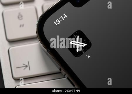 Antalya, Turkey - June 5, 2024: Twitter X logo on smartphone and computer keyboard in the background Stock Photo