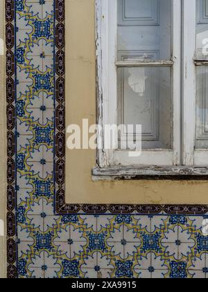 Patterned tiles on an exterior wall of a building in the town of Lagos in southern Portugal's Algarve region, known for its walled old town, cliffs an Stock Photo
