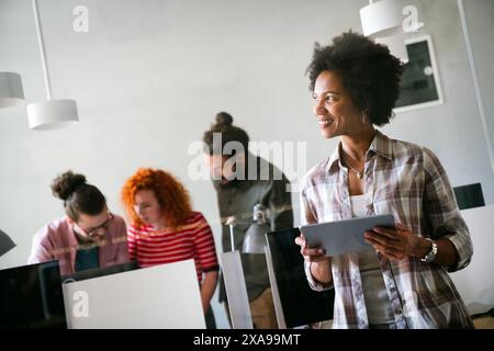 Happy african american female leader holding negotiations meeting with friendly diverse colleague Stock Photo
