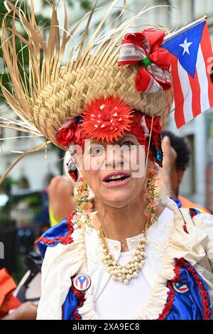 A woman dressed in costume attends the flag-raising ceremony for Puerto Rico at Bowling Green Park on June 4, 2024 in New York City. Stock Photo