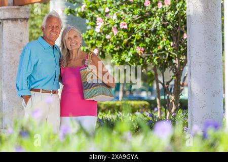 Happy senior man and woman old couple walking together outside in sunshine Stock Photo