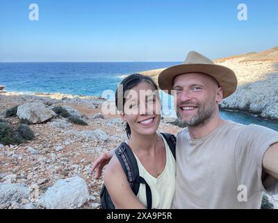 A couple taking a selfie by the sea in Greece Stock Photo