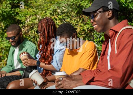 Cheerful funny group of African American friends students spending time outdoors laughing, chatting. Stock Photo