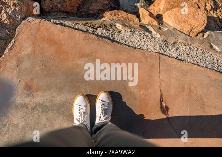 Close-up shot of shoes on rocky ground Stock Photo