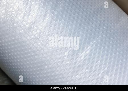 Roll of bubble wrap, close-up photo with selective focus. It is a pliable transparent plastic material with bubbles of air used for packing fragile it Stock Photo