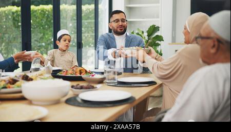 Muslim, family and dinner in home for eid, islamic celebration and serving food on dining table. Ramadan, culture and religious gathering with Stock Photo