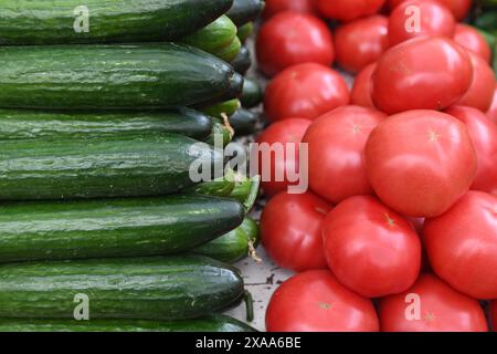 Various tomatoes and cucumbers on display at a market Stock Photo