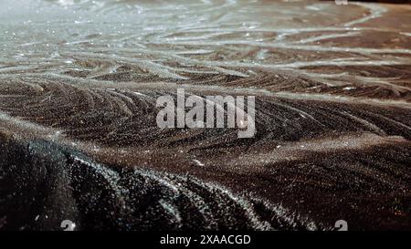 A close-up of damp rocks on beach at night Stock Photo