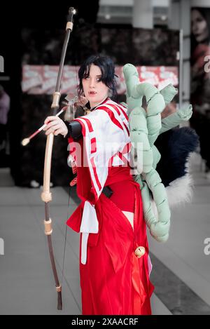 A female in a costume with bow and toy Stock Photo