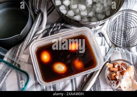 Soft-Boiled Eggs in Soy Sauce Marinade: Making ramen eggs by marination boiled eggs in spiced soy sauce mixture Stock Photo