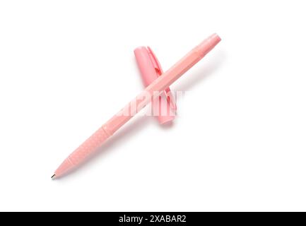 Pink ballpoint pen and cap on white background Stock Photo