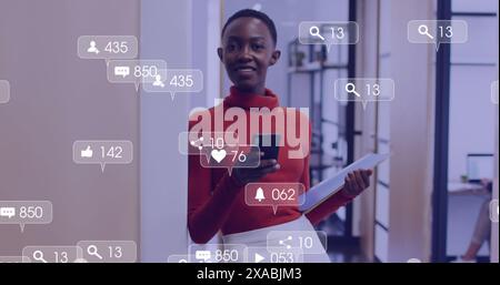 Image of media icons over happy african american businesswoman using smartphone Stock Photo