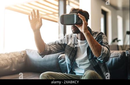 Streamer, man and virtual reality headset in home lounge of cyber experience, metaverse system or gaming connection. Gamer, VR and games in living Stock Photo