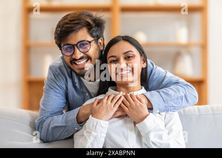 A Man and a Woman Smiling on a Couch, Hugging Stock Photo